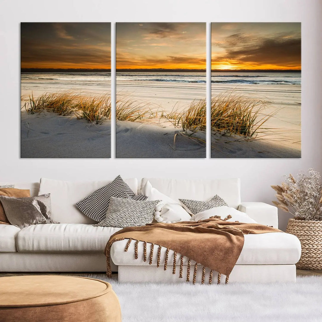 The Ocean Beach Wall Art Canvas Print, a captivating triptych showcasing a sunset over the beach with grass, hangs gracefully. These gallery-wrapped, museum-quality canvases boast a UV-protective coating that preserves their vibrant colors and stunning detail for years to come.