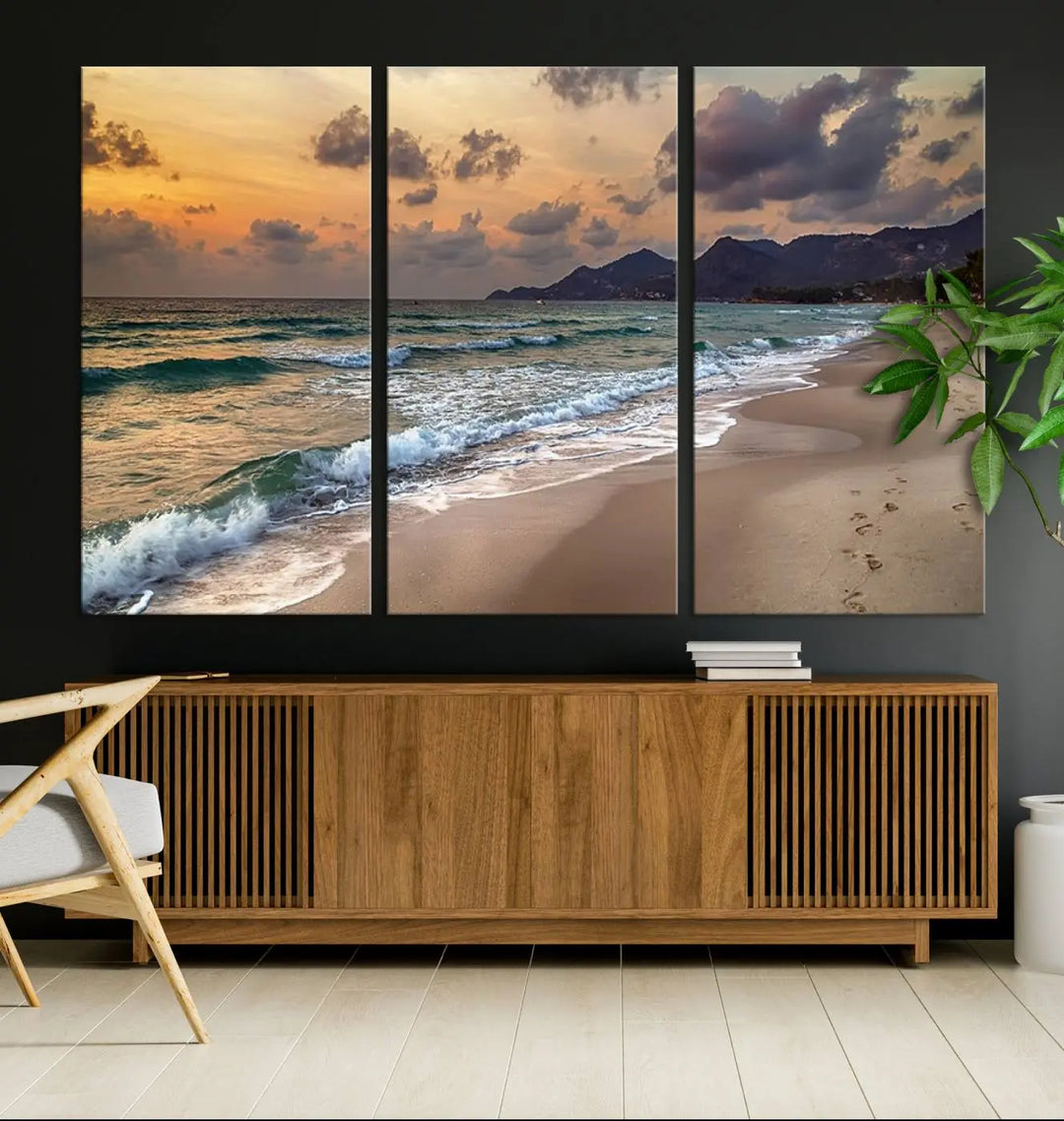 The Ocean Beach Wall Art Canvas Print, a stunning triptych featuring sunset artwork that captures waves and footprints on the sand, beautifully enhances any coastal decor.