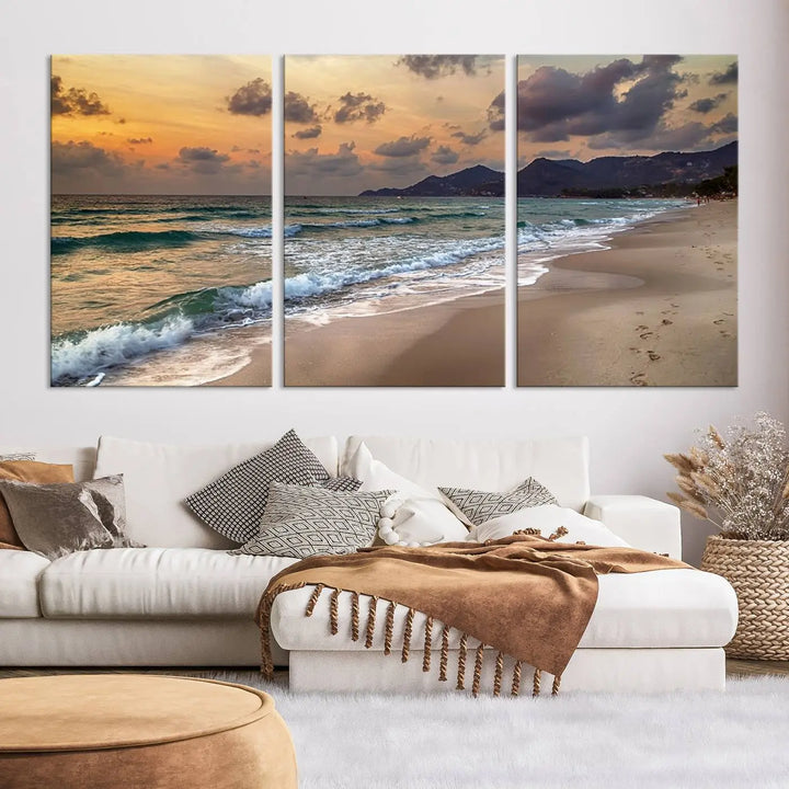 The Ocean Beach Wall Art Canvas Print, a stunning triptych featuring sunset artwork that captures waves and footprints on the sand, beautifully enhances any coastal decor.