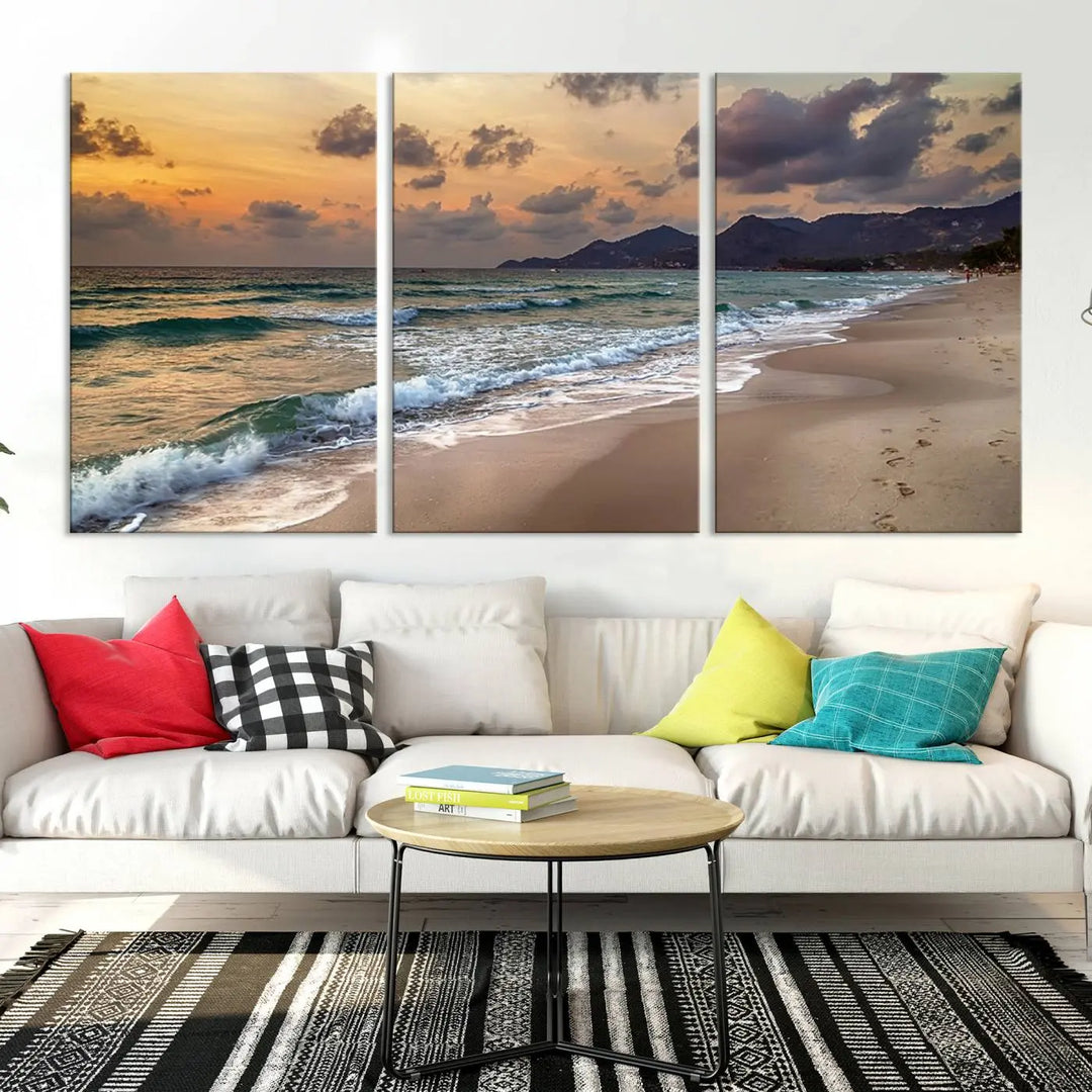 The Ocean Beach Wall Art Canvas Print, a stunning triptych featuring sunset artwork that captures waves and footprints on the sand, beautifully enhances any coastal decor.