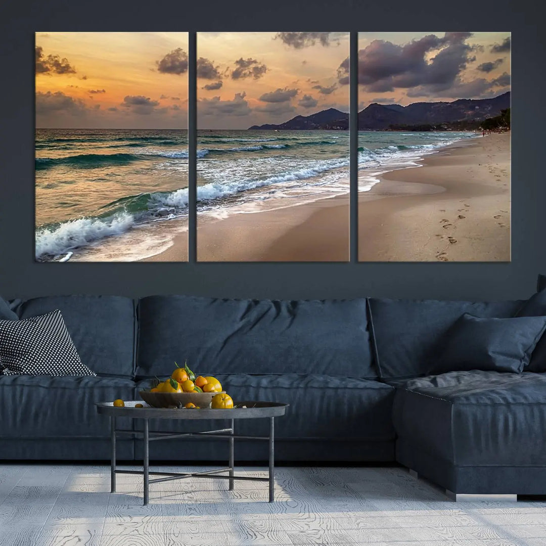 The Ocean Beach Wall Art Canvas Print, a stunning triptych featuring sunset artwork that captures waves and footprints on the sand, beautifully enhances any coastal decor.