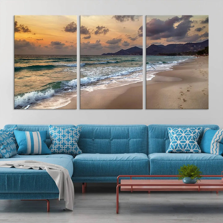 The Ocean Beach Wall Art Canvas Print, a stunning triptych featuring sunset artwork that captures waves and footprints on the sand, beautifully enhances any coastal decor.