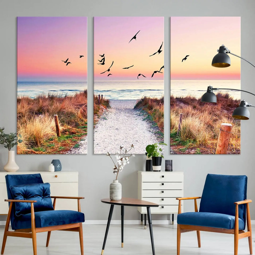 The "Ocean Pathway Sunset Canvas Art" beautifully depicts a tranquil coastal beach walk at sunset, featuring birds in flight across a vividly colorful sky. This piece is crafted using giclee print technology on canvas to ensure vibrant colors and exquisite detail for a relaxing wall art experience.