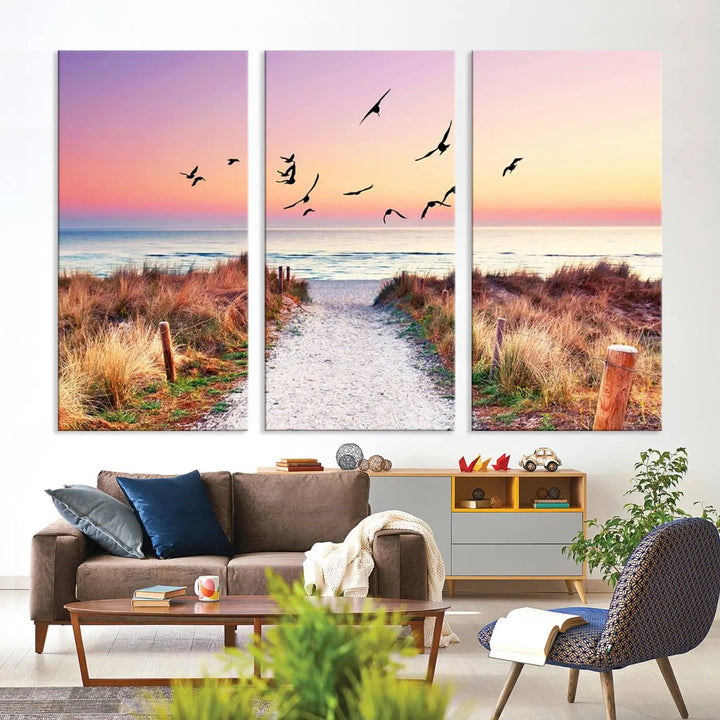 The "Ocean Pathway Sunset Canvas Art" beautifully depicts a tranquil coastal beach walk at sunset, featuring birds in flight across a vividly colorful sky. This piece is crafted using giclee print technology on canvas to ensure vibrant colors and exquisite detail for a relaxing wall art experience.