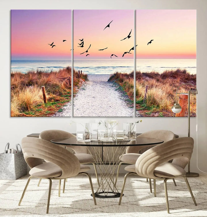 The "Ocean Pathway Sunset Canvas Art" beautifully depicts a tranquil coastal beach walk at sunset, featuring birds in flight across a vividly colorful sky. This piece is crafted using giclee print technology on canvas to ensure vibrant colors and exquisite detail for a relaxing wall art experience.