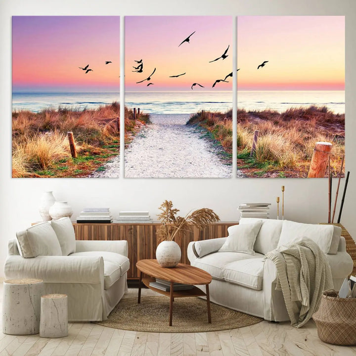 The "Ocean Pathway Sunset Canvas Art" beautifully depicts a tranquil coastal beach walk at sunset, featuring birds in flight across a vividly colorful sky. This piece is crafted using giclee print technology on canvas to ensure vibrant colors and exquisite detail for a relaxing wall art experience.