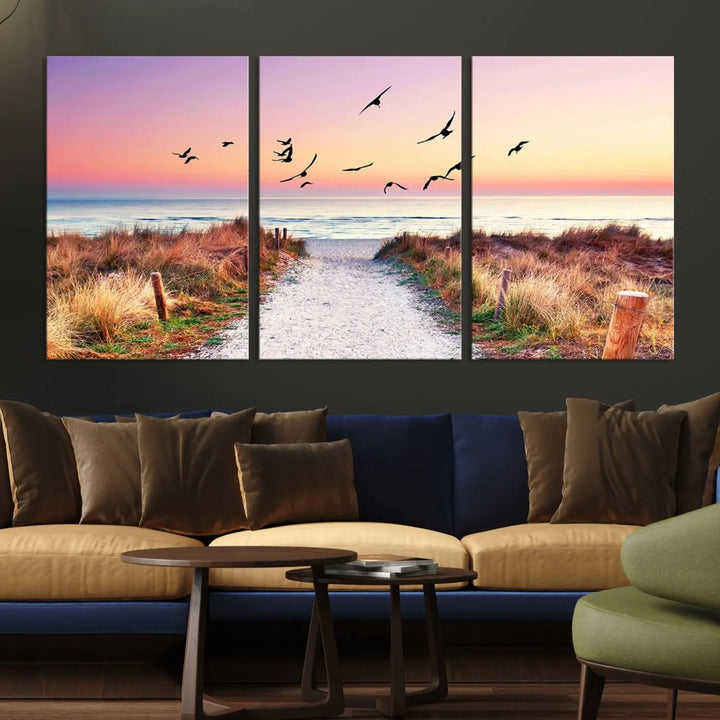 The "Ocean Pathway Sunset Canvas Art" beautifully depicts a tranquil coastal beach walk at sunset, featuring birds in flight across a vividly colorful sky. This piece is crafted using giclee print technology on canvas to ensure vibrant colors and exquisite detail for a relaxing wall art experience.