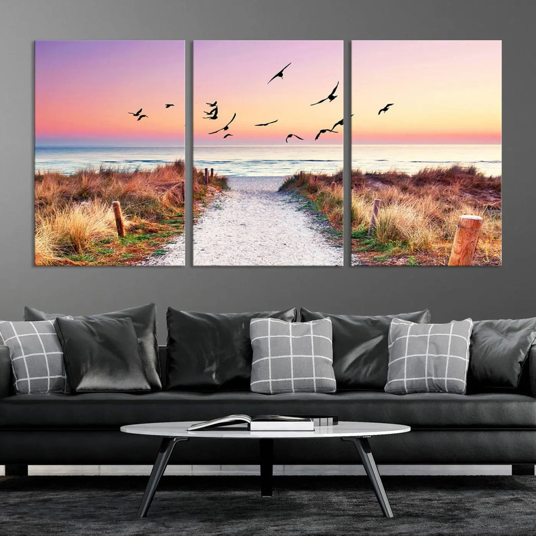 The "Ocean Pathway Sunset Canvas Art" beautifully depicts a tranquil coastal beach walk at sunset, featuring birds in flight across a vividly colorful sky. This piece is crafted using giclee print technology on canvas to ensure vibrant colors and exquisite detail for a relaxing wall art experience.