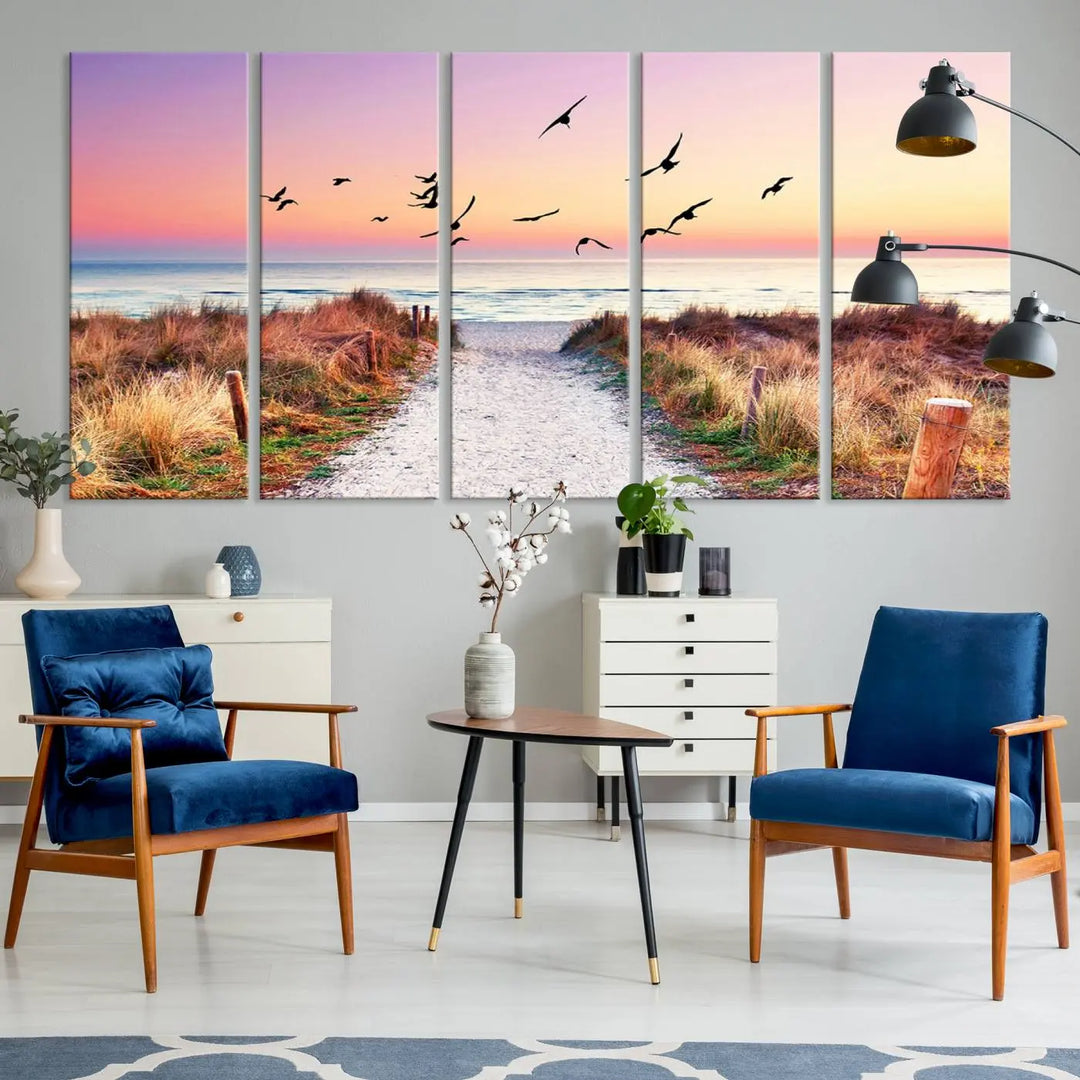 The "Ocean Pathway Sunset Canvas Art" beautifully depicts a tranquil coastal beach walk at sunset, featuring birds in flight across a vividly colorful sky. This piece is crafted using giclee print technology on canvas to ensure vibrant colors and exquisite detail for a relaxing wall art experience.