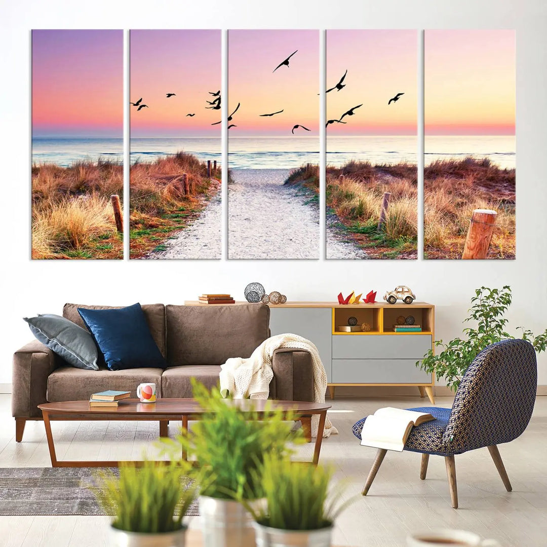 The "Ocean Pathway Sunset Canvas Art" beautifully depicts a tranquil coastal beach walk at sunset, featuring birds in flight across a vividly colorful sky. This piece is crafted using giclee print technology on canvas to ensure vibrant colors and exquisite detail for a relaxing wall art experience.