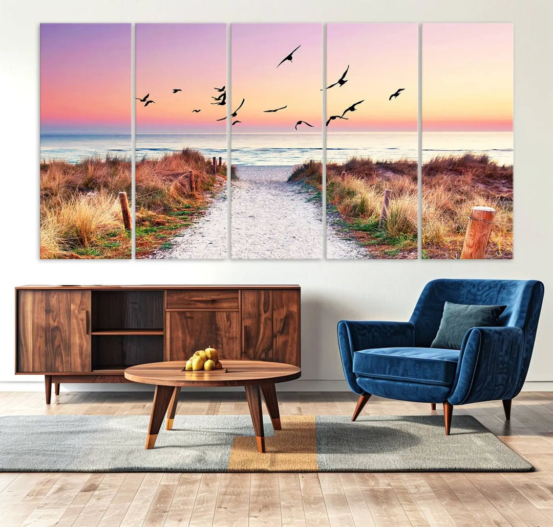 The "Ocean Pathway Sunset Canvas Art" beautifully depicts a tranquil coastal beach walk at sunset, featuring birds in flight across a vividly colorful sky. This piece is crafted using giclee print technology on canvas to ensure vibrant colors and exquisite detail for a relaxing wall art experience.