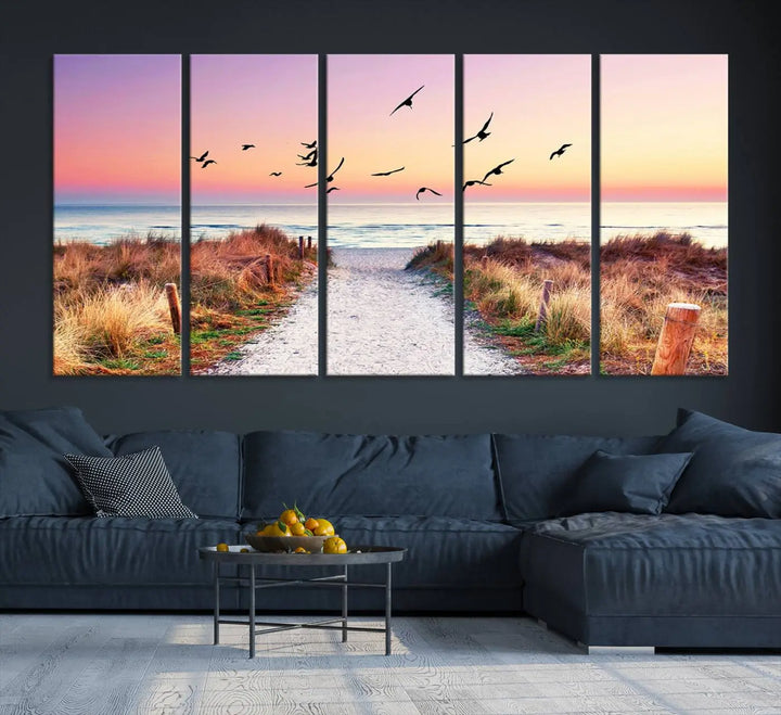 The "Ocean Pathway Sunset Canvas Art" beautifully depicts a tranquil coastal beach walk at sunset, featuring birds in flight across a vividly colorful sky. This piece is crafted using giclee print technology on canvas to ensure vibrant colors and exquisite detail for a relaxing wall art experience.