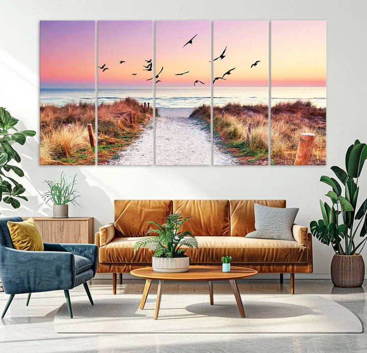 The "Ocean Pathway Sunset Canvas Art" beautifully depicts a tranquil coastal beach walk at sunset, featuring birds in flight across a vividly colorful sky. This piece is crafted using giclee print technology on canvas to ensure vibrant colors and exquisite detail for a relaxing wall art experience.