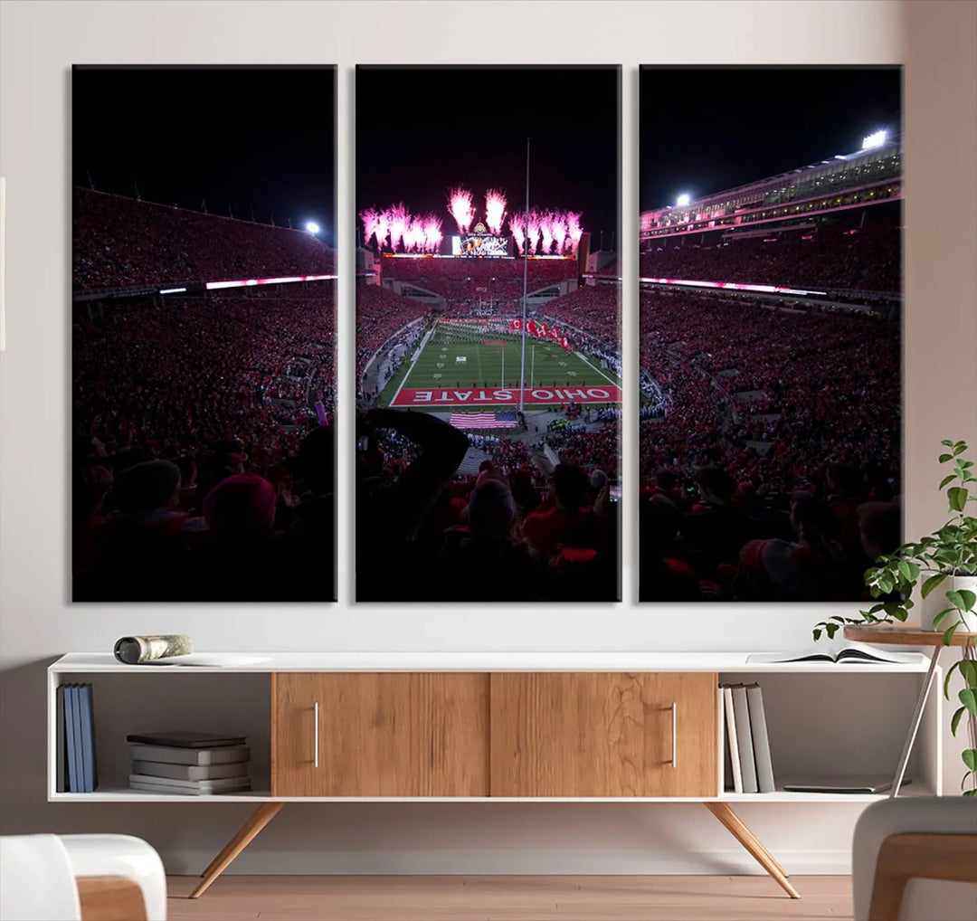 The living room features a breathtaking Ohio State University Buckeyes Football Team Print, depicting a stadium packed with fans, fireworks illuminating the sky, and Ohio State on the field. This Columbus Ohio Stadium Wall Art Canvas Print offers a vibrant display with a gallery-quality finish that instantly draws attention.