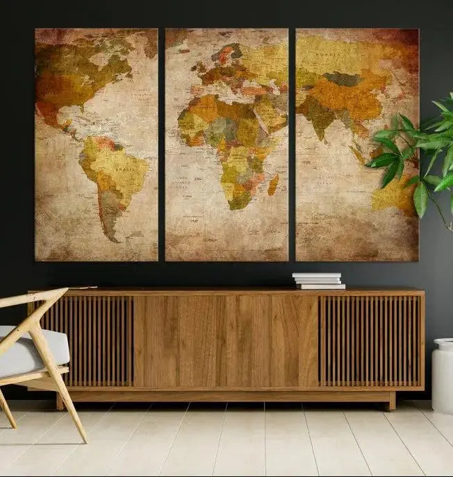 The Old Antique World Map Wall Art Canvas Print, featuring a three-panel vintage design and crafted with museum-quality canvas and UV-protective coating, hangs elegantly against a dark wall.