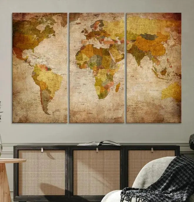 The Old Antique World Map Wall Art Canvas Print, featuring a three-panel vintage design and crafted with museum-quality canvas and UV-protective coating, hangs elegantly against a dark wall.