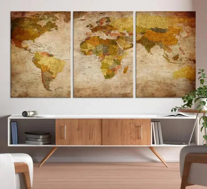 The Old Antique World Map Wall Art Canvas Print, featuring a three-panel vintage design and crafted with museum-quality canvas and UV-protective coating, hangs elegantly against a dark wall.