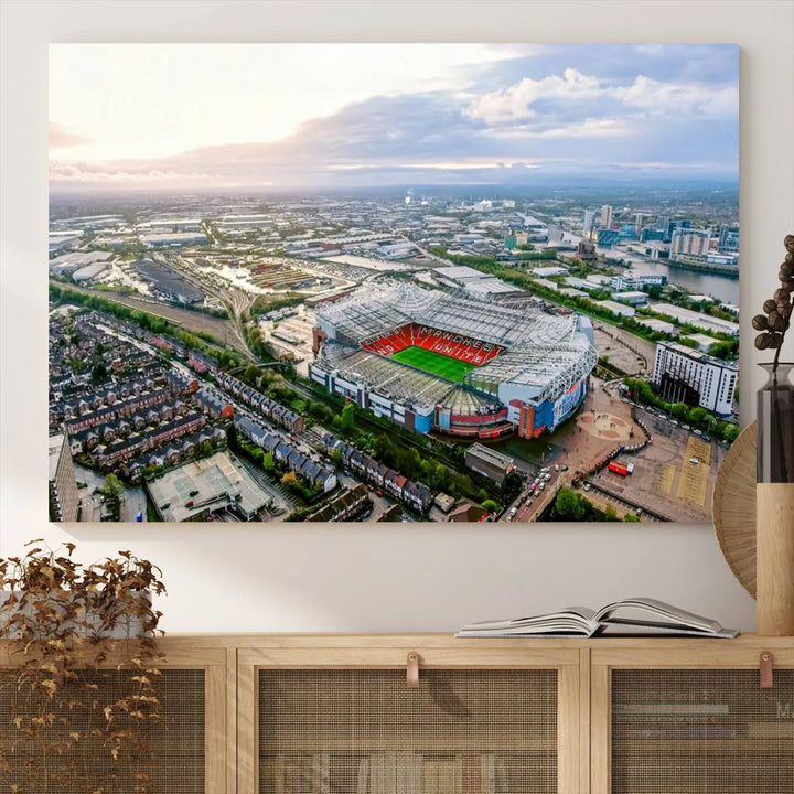 The "Old Trafford Manchester United Stadium Wall Art Canvas Print" adorns the room, showcasing an aerial view of Old Trafford at sunset. This three-panel wall art is perfect for any devoted Manchester United football fan.