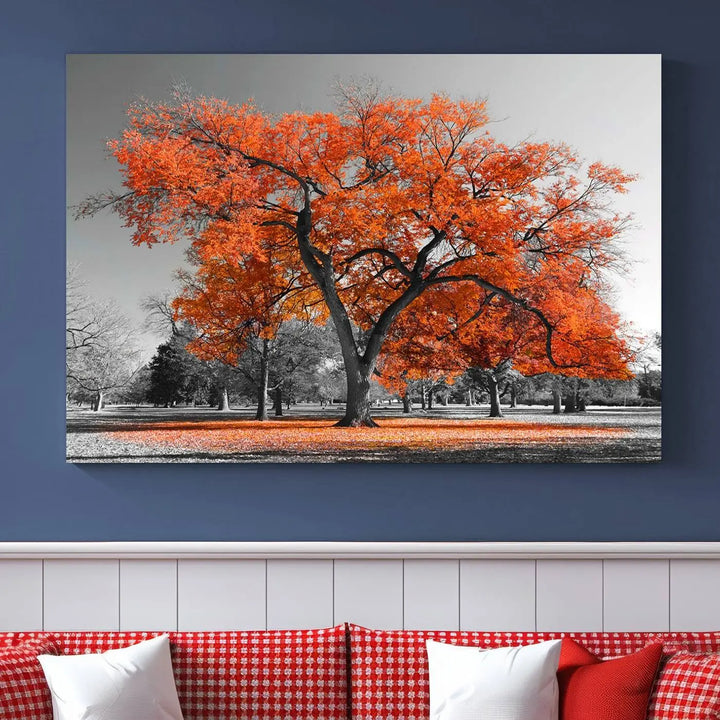 The "Orange Autumn Tree Canvas Wall Art Print" features a triptych of a tree with vibrant orange leaves set in a grayscale park. It's printed on museum-quality canvas and safeguarded by a UV-protective coating, making it the perfect artwork for any space.