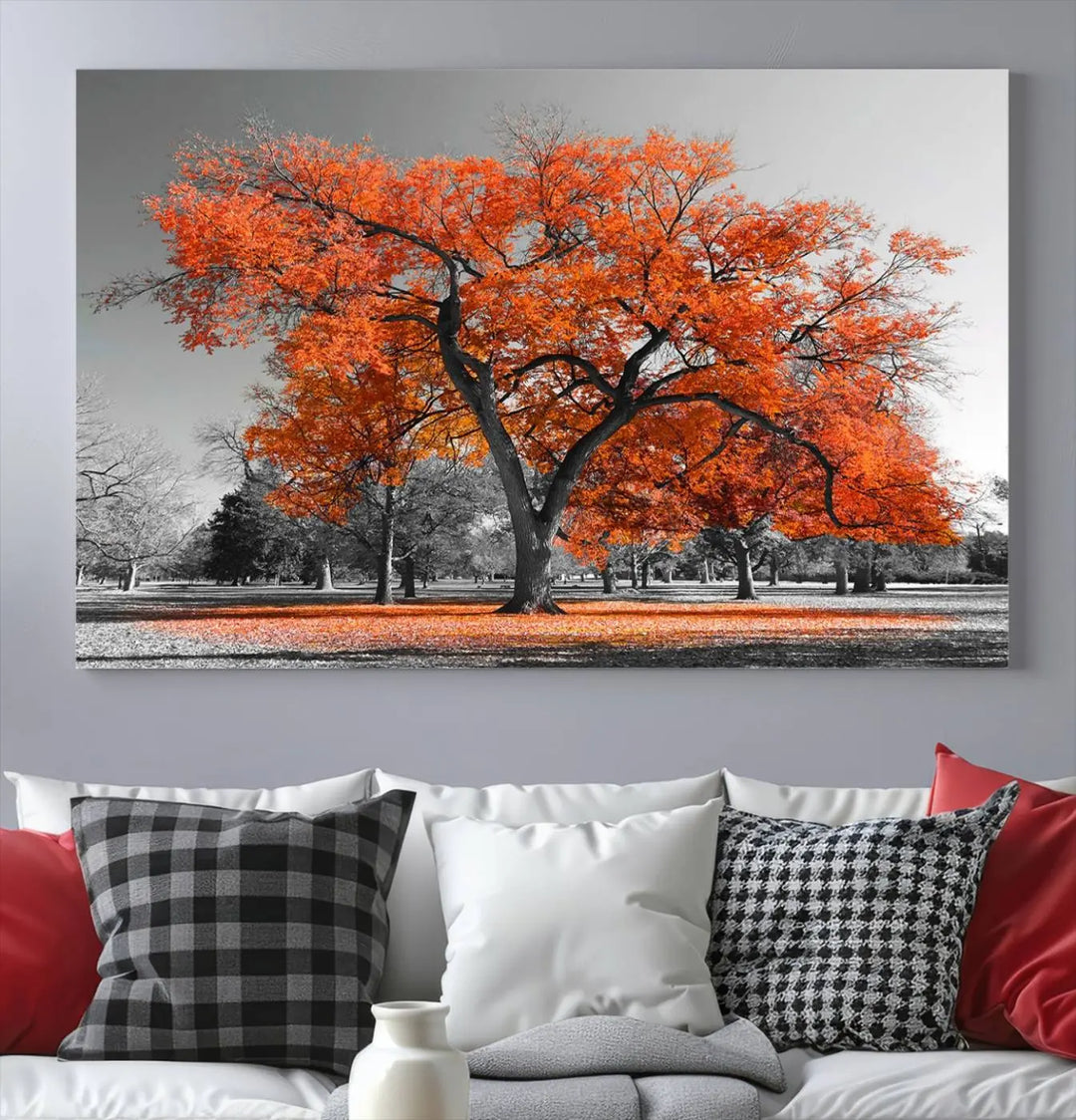 The "Orange Autumn Tree Canvas Wall Art Print" features a triptych of a tree with vibrant orange leaves set in a grayscale park. It's printed on museum-quality canvas and safeguarded by a UV-protective coating, making it the perfect artwork for any space.