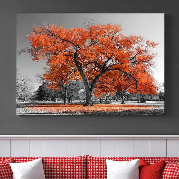 The "Orange Autumn Tree Canvas Wall Art Print" features a triptych of a tree with vibrant orange leaves set in a grayscale park. It's printed on museum-quality canvas and safeguarded by a UV-protective coating, making it the perfect artwork for any space.