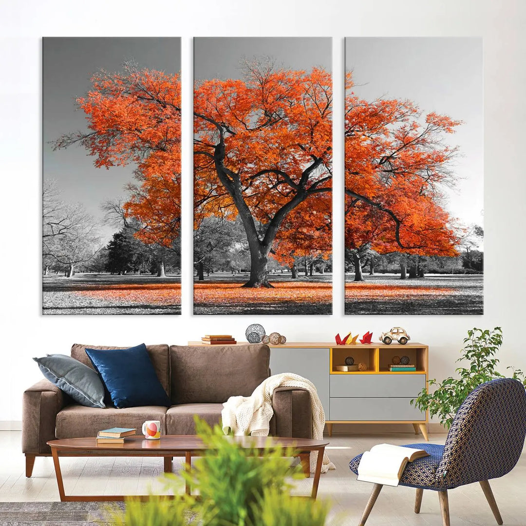 The "Orange Autumn Tree Canvas Wall Art Print" features a triptych of a tree with vibrant orange leaves set in a grayscale park. It's printed on museum-quality canvas and safeguarded by a UV-protective coating, making it the perfect artwork for any space.