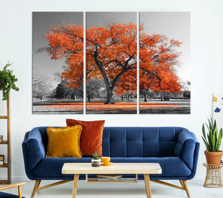 The "Orange Autumn Tree Canvas Wall Art Print" features a triptych of a tree with vibrant orange leaves set in a grayscale park. It's printed on museum-quality canvas and safeguarded by a UV-protective coating, making it the perfect artwork for any space.