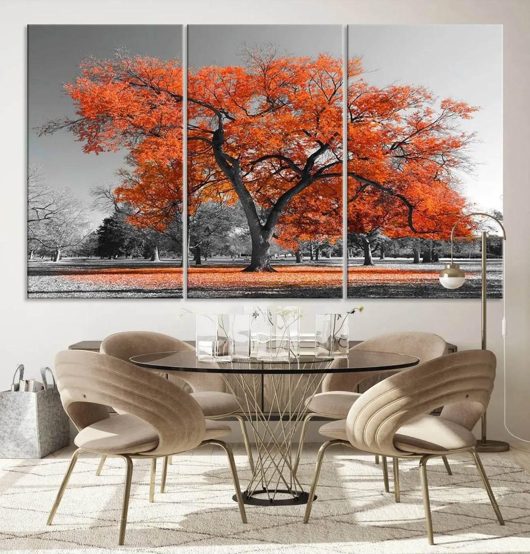 The "Orange Autumn Tree Canvas Wall Art Print" features a triptych of a tree with vibrant orange leaves set in a grayscale park. It's printed on museum-quality canvas and safeguarded by a UV-protective coating, making it the perfect artwork for any space.