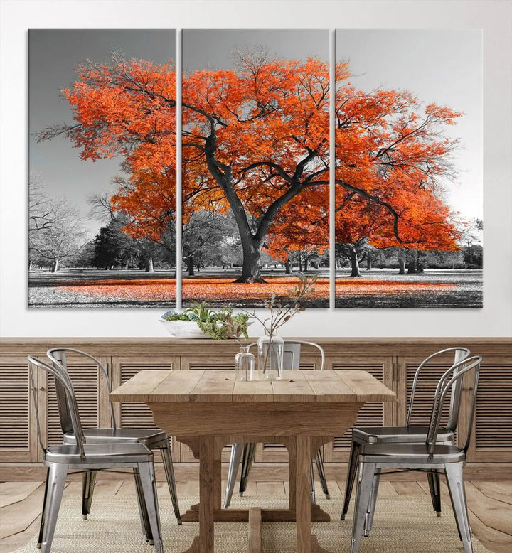 The "Orange Autumn Tree Canvas Wall Art Print" features a triptych of a tree with vibrant orange leaves set in a grayscale park. It's printed on museum-quality canvas and safeguarded by a UV-protective coating, making it the perfect artwork for any space.