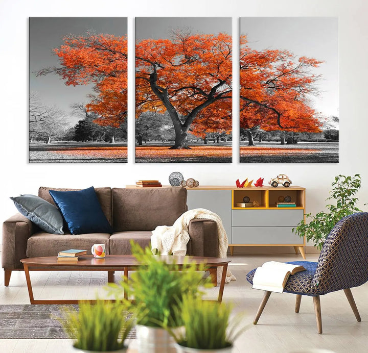 The "Orange Autumn Tree Canvas Wall Art Print" features a triptych of a tree with vibrant orange leaves set in a grayscale park. It's printed on museum-quality canvas and safeguarded by a UV-protective coating, making it the perfect artwork for any space.