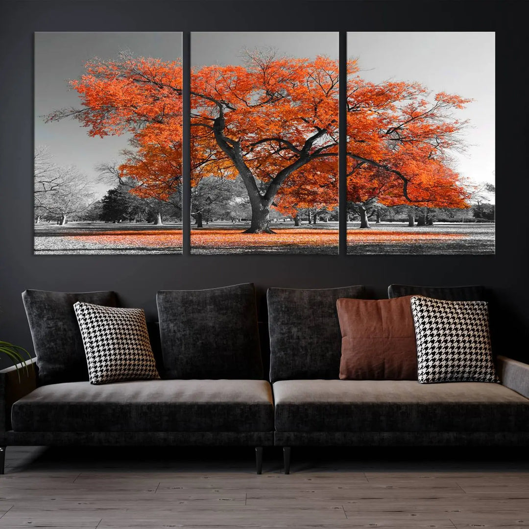 The "Orange Autumn Tree Canvas Wall Art Print" features a triptych of a tree with vibrant orange leaves set in a grayscale park. It's printed on museum-quality canvas and safeguarded by a UV-protective coating, making it the perfect artwork for any space.