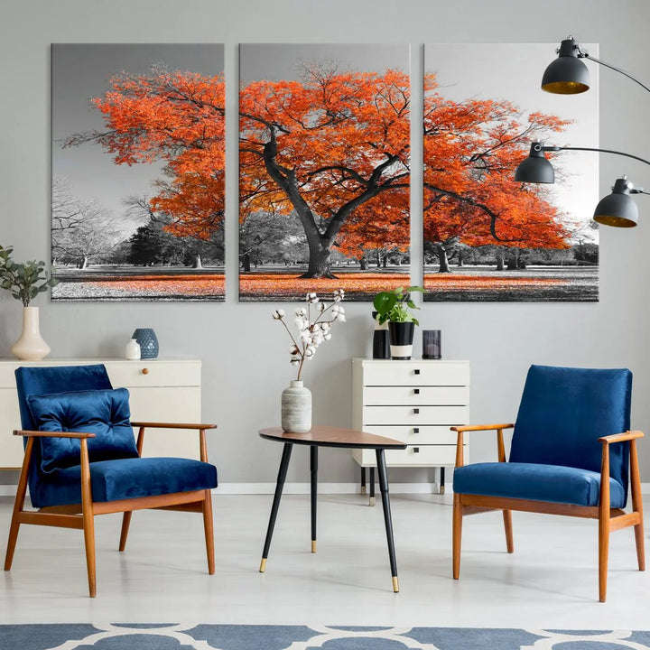 The "Orange Autumn Tree Canvas Wall Art Print" features a triptych of a tree with vibrant orange leaves set in a grayscale park. It's printed on museum-quality canvas and safeguarded by a UV-protective coating, making it the perfect artwork for any space.