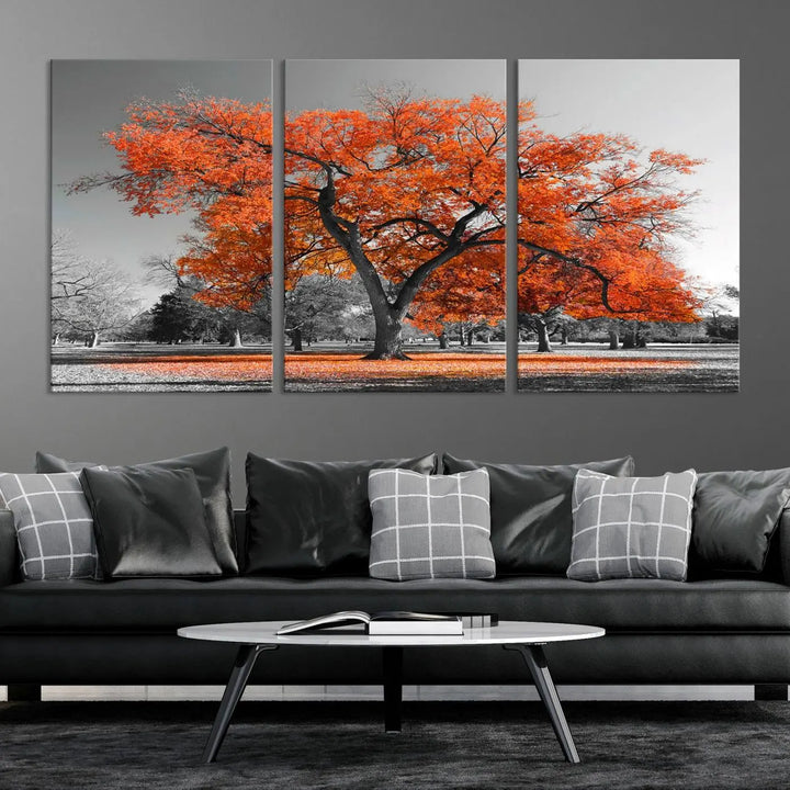 The "Orange Autumn Tree Canvas Wall Art Print" features a triptych of a tree with vibrant orange leaves set in a grayscale park. It's printed on museum-quality canvas and safeguarded by a UV-protective coating, making it the perfect artwork for any space.