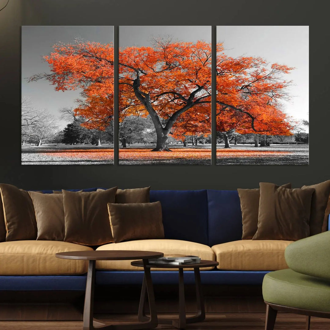 The "Orange Autumn Tree Canvas Wall Art Print" features a triptych of a tree with vibrant orange leaves set in a grayscale park. It's printed on museum-quality canvas and safeguarded by a UV-protective coating, making it the perfect artwork for any space.