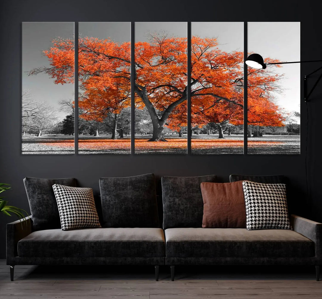 The "Orange Autumn Tree Canvas Wall Art Print" features a triptych of a tree with vibrant orange leaves set in a grayscale park. It's printed on museum-quality canvas and safeguarded by a UV-protective coating, making it the perfect artwork for any space.