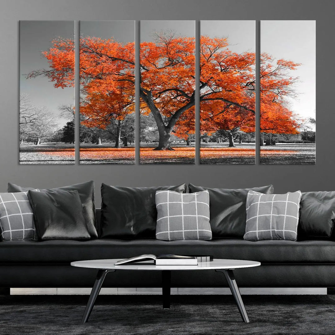 The "Orange Autumn Tree Canvas Wall Art Print" features a triptych of a tree with vibrant orange leaves set in a grayscale park. It's printed on museum-quality canvas and safeguarded by a UV-protective coating, making it the perfect artwork for any space.