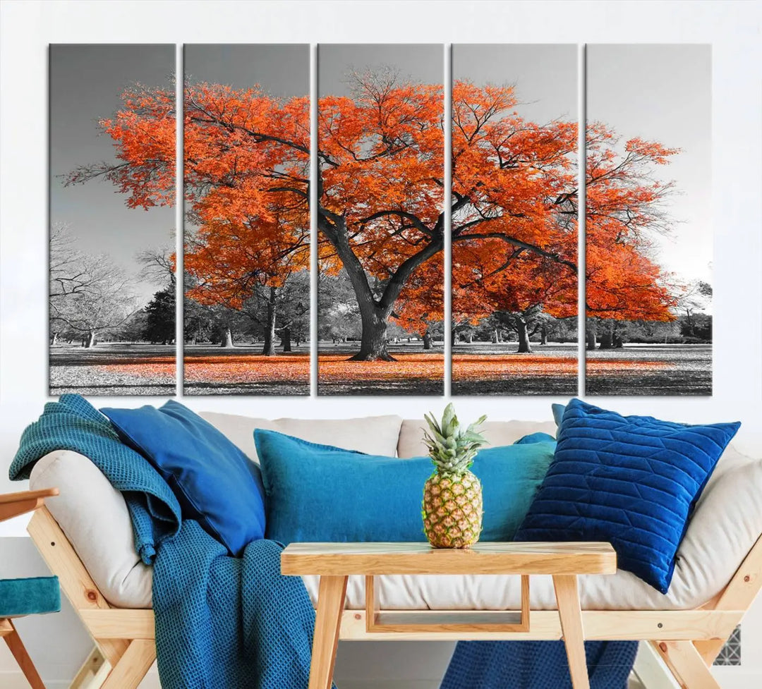 The "Orange Autumn Tree Canvas Wall Art Print" features a triptych of a tree with vibrant orange leaves set in a grayscale park. It's printed on museum-quality canvas and safeguarded by a UV-protective coating, making it the perfect artwork for any space.