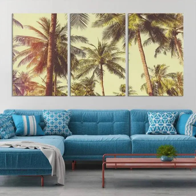 The living room features the Palm Tree Wall Art Tropical Coast Canvas Print, displayed as a triptych on museum-quality canvas. Each piece is gallery wrapped for a polished look.