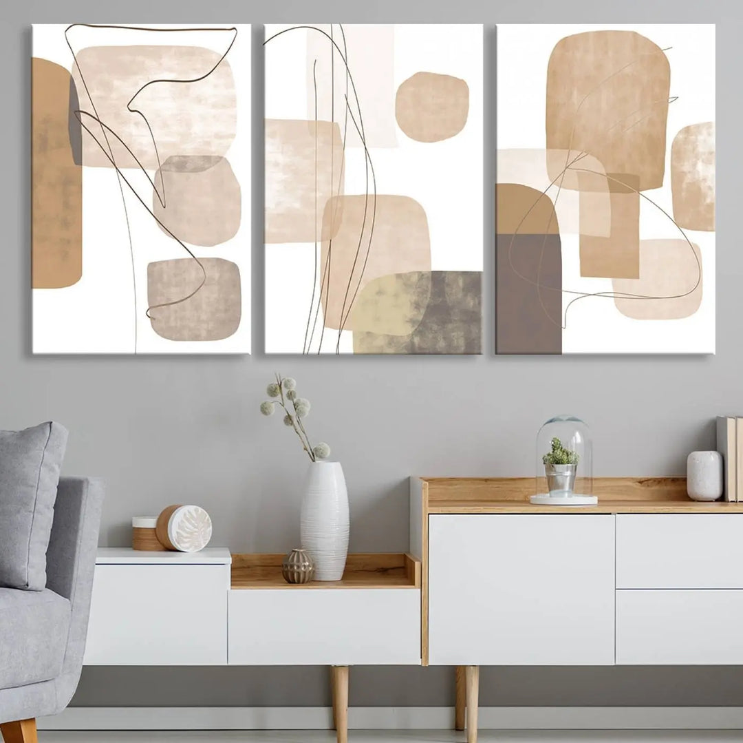 Pastel Boho Wall Art Canvas Print Set Mid-Century Prints featuring abstract art with beige and brown shapes adorns a dark wall, gallery wrapped for a sleek look.