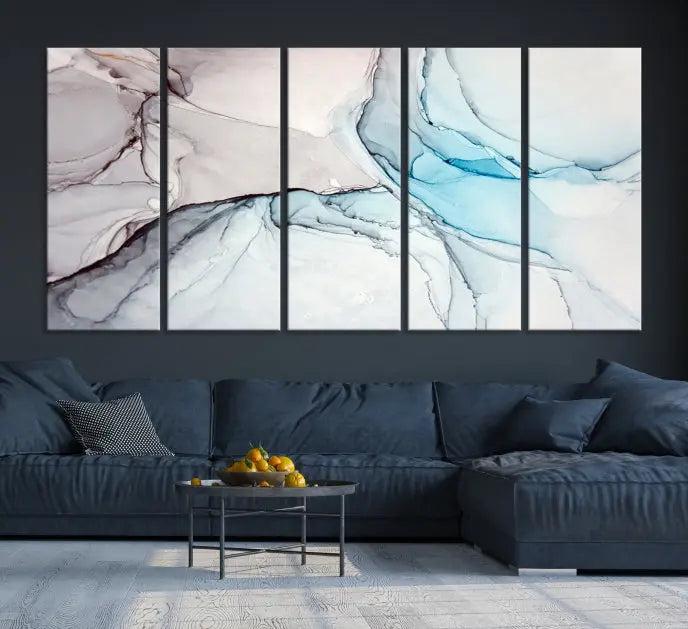 The "Pastel Marble Fluid Effect Wall Art Abstract Canvas Wall Art Print" elegantly enhances the area above a dark blue sofa. This art piece comes ready to hang.