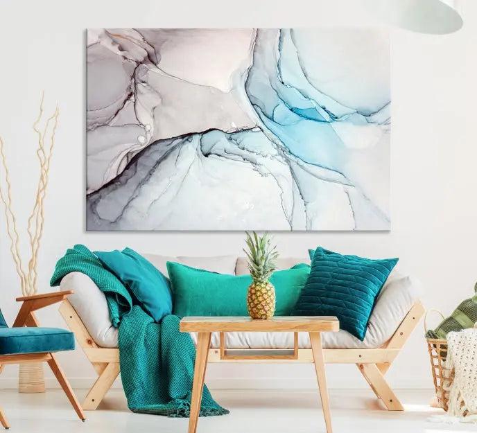 The "Pastel Marble Fluid Effect Wall Art Abstract Canvas Wall Art Print" elegantly enhances the area above a dark blue sofa. This art piece comes ready to hang.