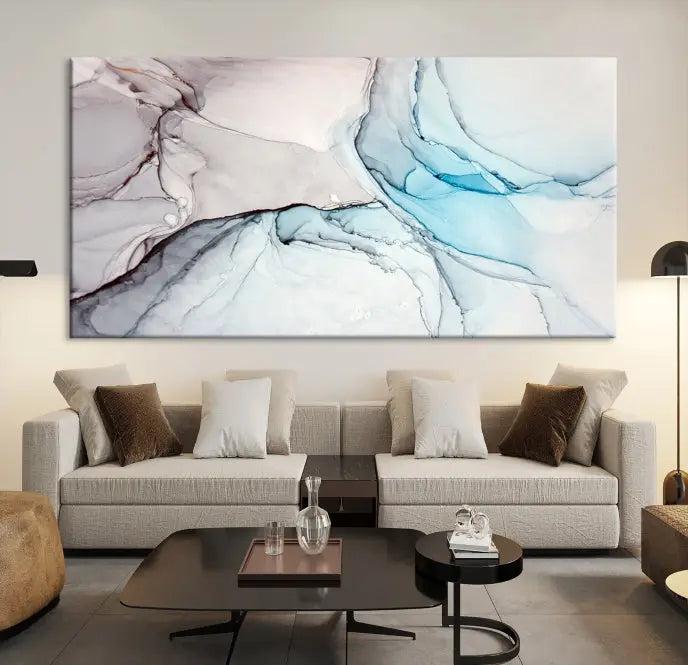 The "Pastel Marble Fluid Effect Wall Art Abstract Canvas Wall Art Print" elegantly enhances the area above a dark blue sofa. This art piece comes ready to hang.