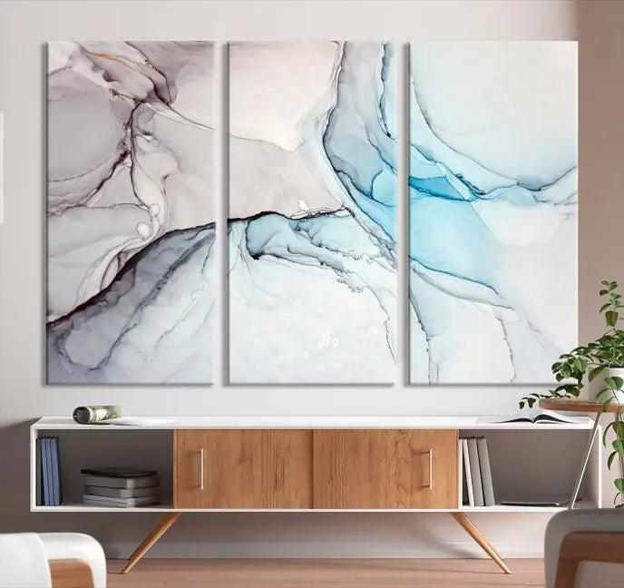 The "Pastel Marble Fluid Effect Wall Art Abstract Canvas Wall Art Print" elegantly enhances the area above a dark blue sofa. This art piece comes ready to hang.