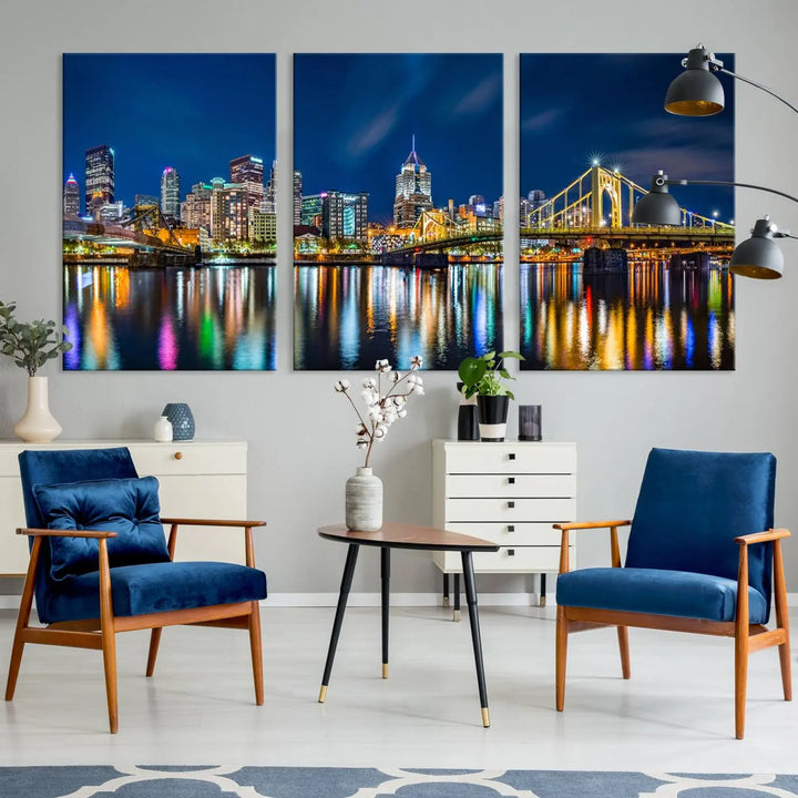 The living room features a gallery-wrapped triptych of Pittsburgh's skyline at night, reflecting on water. This Pittsburgh Skyline Canvas Wall Art is displayed above the cabinets and is printed on museum-quality canvas with a UV-protective coating to maintain its lasting vibrancy.