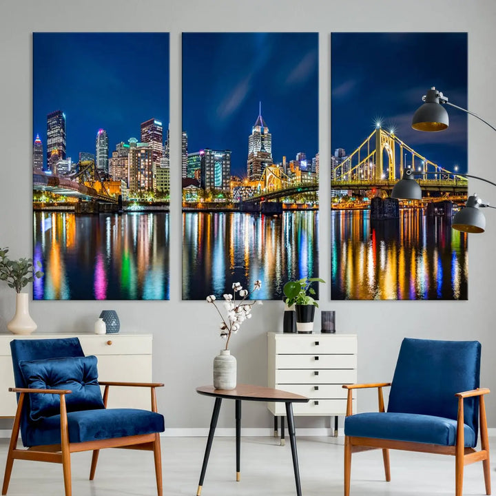 The living room features a gallery-wrapped triptych of Pittsburgh's skyline at night, reflecting on water. This Pittsburgh Skyline Canvas Wall Art is displayed above the cabinets and is printed on museum-quality canvas with a UV-protective coating to maintain its lasting vibrancy.