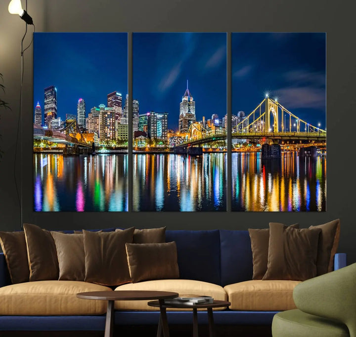 The living room features a gallery-wrapped triptych of Pittsburgh's skyline at night, reflecting on water. This Pittsburgh Skyline Canvas Wall Art is displayed above the cabinets and is printed on museum-quality canvas with a UV-protective coating to maintain its lasting vibrancy.