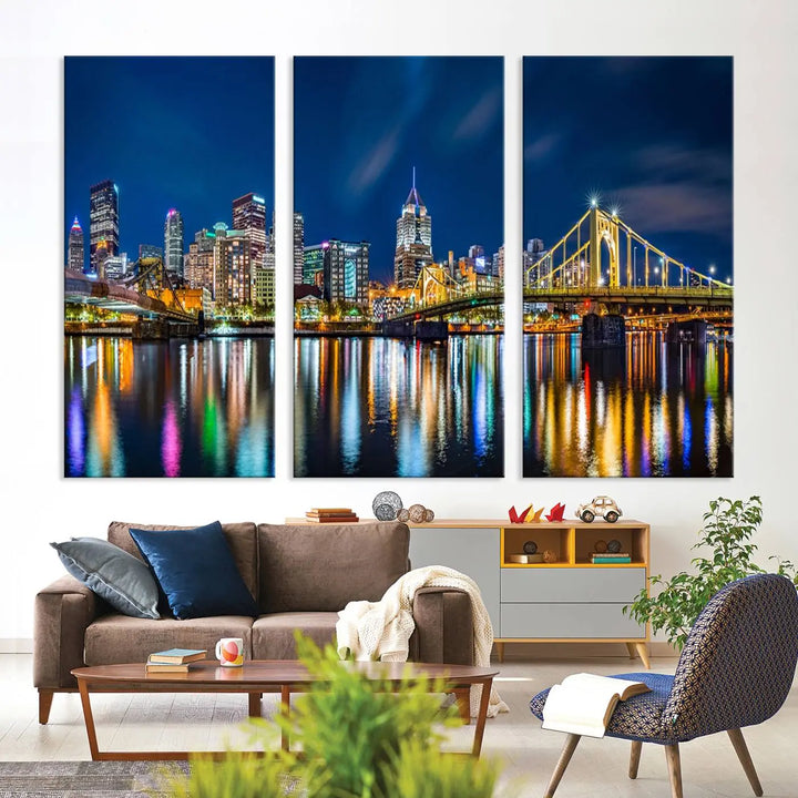 The living room features a gallery-wrapped triptych of Pittsburgh's skyline at night, reflecting on water. This Pittsburgh Skyline Canvas Wall Art is displayed above the cabinets and is printed on museum-quality canvas with a UV-protective coating to maintain its lasting vibrancy.