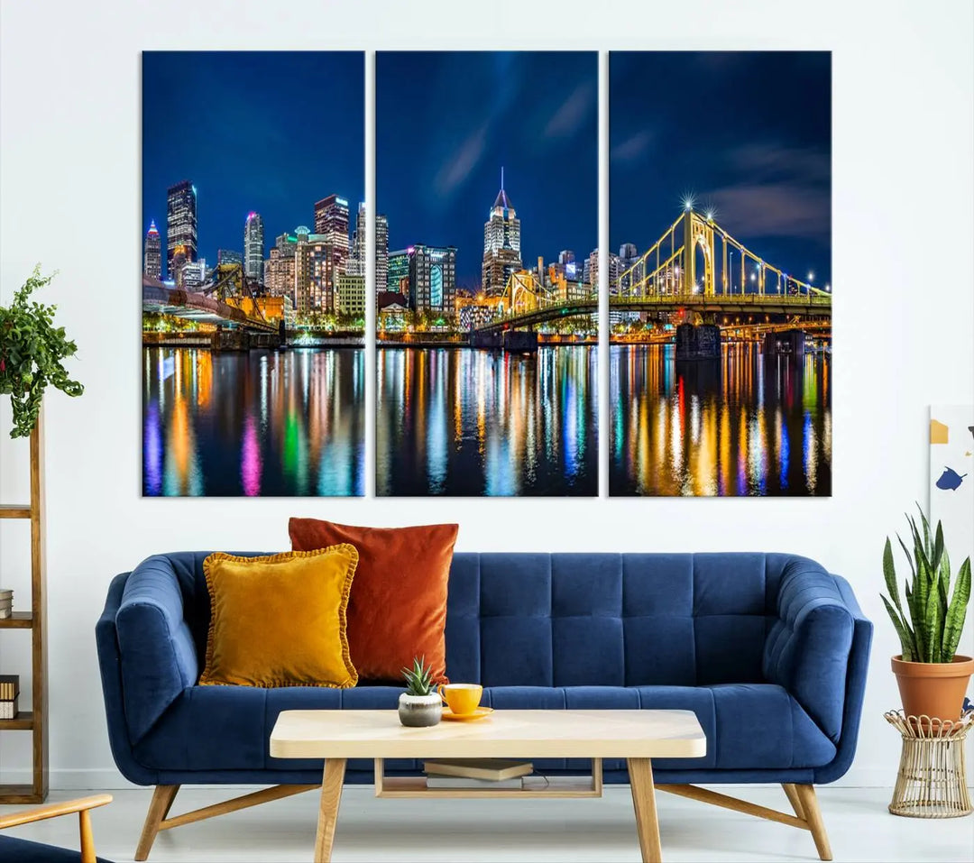 The living room features a gallery-wrapped triptych of Pittsburgh's skyline at night, reflecting on water. This Pittsburgh Skyline Canvas Wall Art is displayed above the cabinets and is printed on museum-quality canvas with a UV-protective coating to maintain its lasting vibrancy.