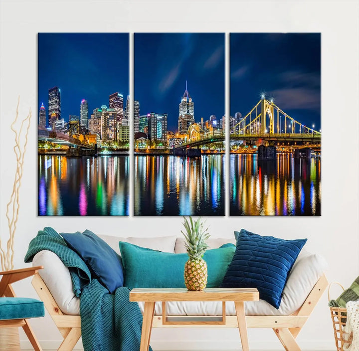 The living room features a gallery-wrapped triptych of Pittsburgh's skyline at night, reflecting on water. This Pittsburgh Skyline Canvas Wall Art is displayed above the cabinets and is printed on museum-quality canvas with a UV-protective coating to maintain its lasting vibrancy.