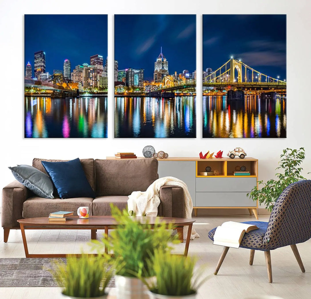 The living room features a gallery-wrapped triptych of Pittsburgh's skyline at night, reflecting on water. This Pittsburgh Skyline Canvas Wall Art is displayed above the cabinets and is printed on museum-quality canvas with a UV-protective coating to maintain its lasting vibrancy.